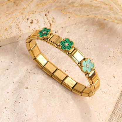 Gold tone bracelet with green clover charms and crystal accents, elegant fashion jewelry for women