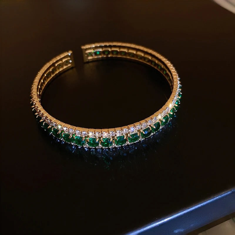 Elegant gold bangle with emerald and diamond accents, luxury fashion jewelry
