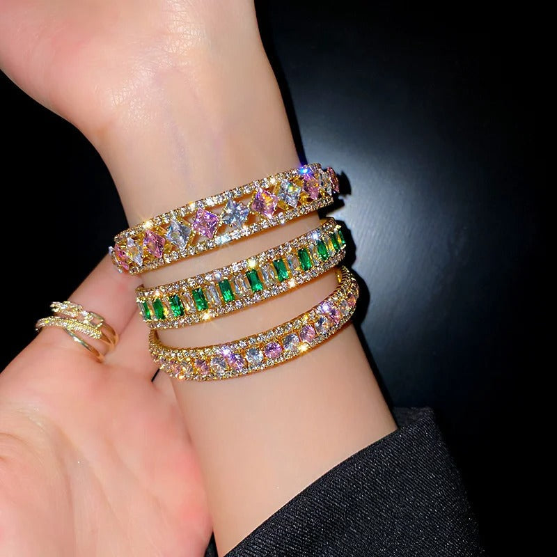 Elegant gold bangles with colorful gemstones and crystals, perfect for fashion jewelry lovers.