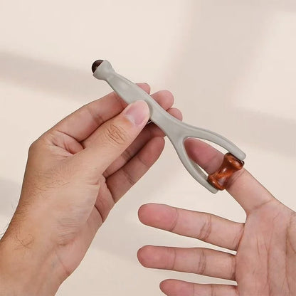 Hand holding dual-ended massage tool with wooden roller for relaxation and muscle relief