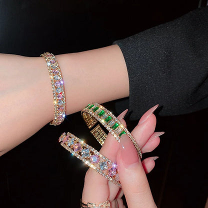 Elegant gold bangles with colorful gemstones and crystals, perfect for fashion accessories and luxury jewelry.