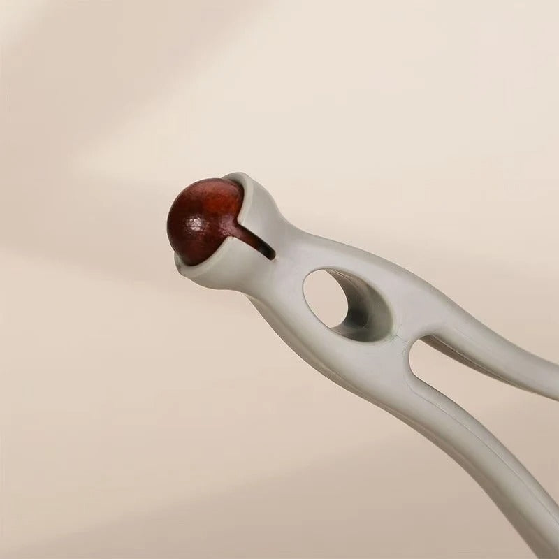 White nut cracker holding a brown walnut, kitchen tool for cracking nuts easily