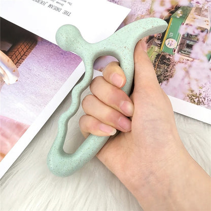 Hand holding mint green ergonomic massage tool for muscle relief and relaxation