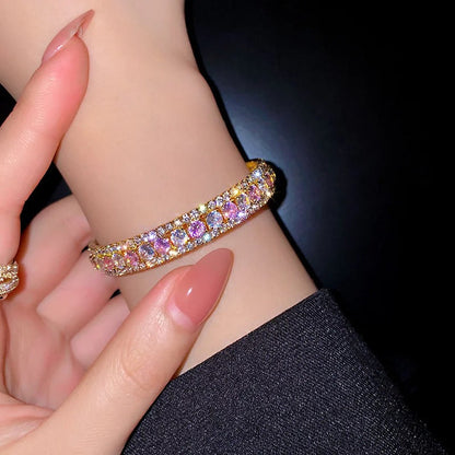 Elegant gold bracelet with sparkling pink and clear crystals, perfect for fashion accessories.