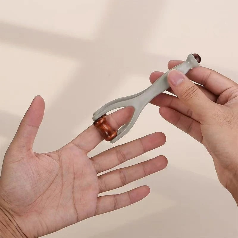 Hand holding dual roller massager for palm and finger relief, portable self-massage tool