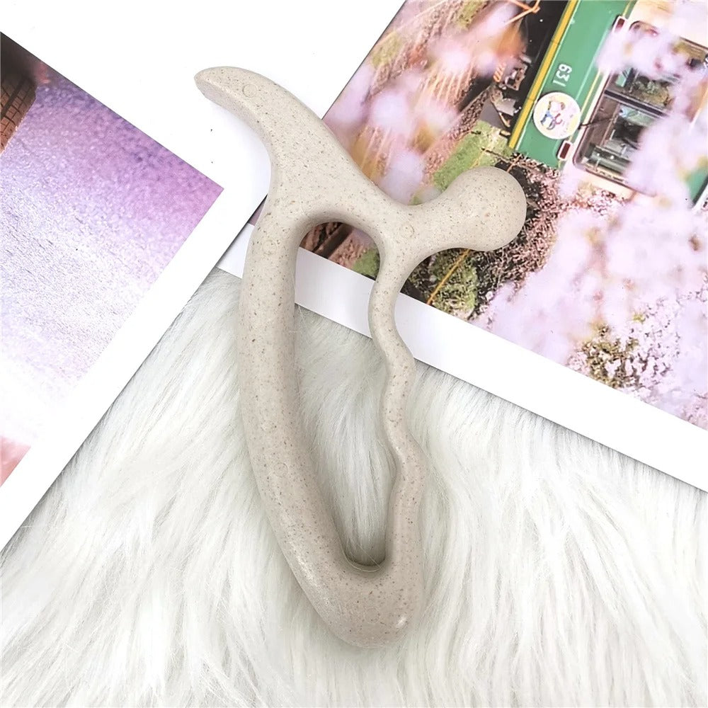 Beige ergonomic massage tool on fluffy white surface with photo prints, ideal for home wellness and relaxation.