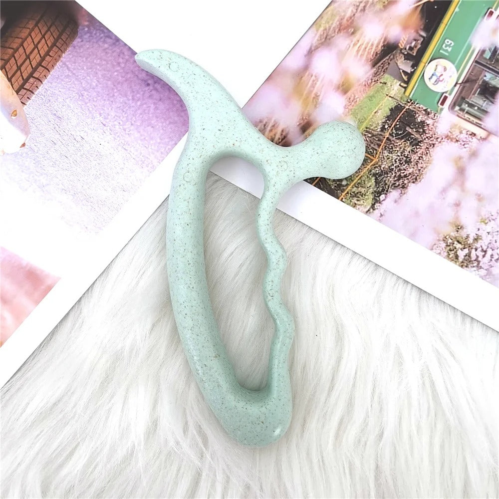 Mint green ergonomic massage tool on fluffy white surface with photo prints