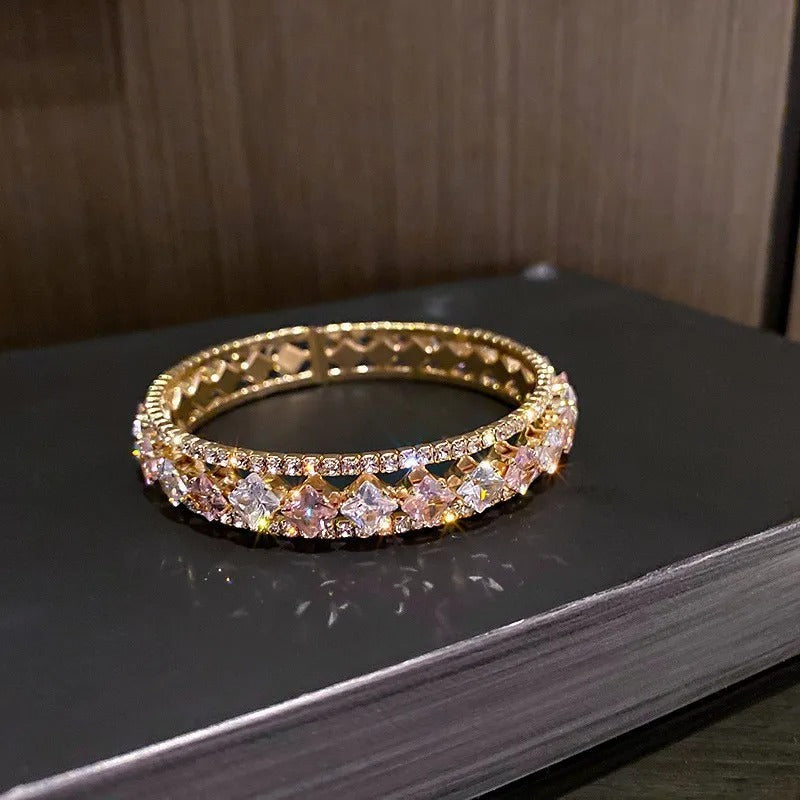 Elegant gold bangle with pink and clear crystals, perfect for fashion accessories and luxury jewelry gifts